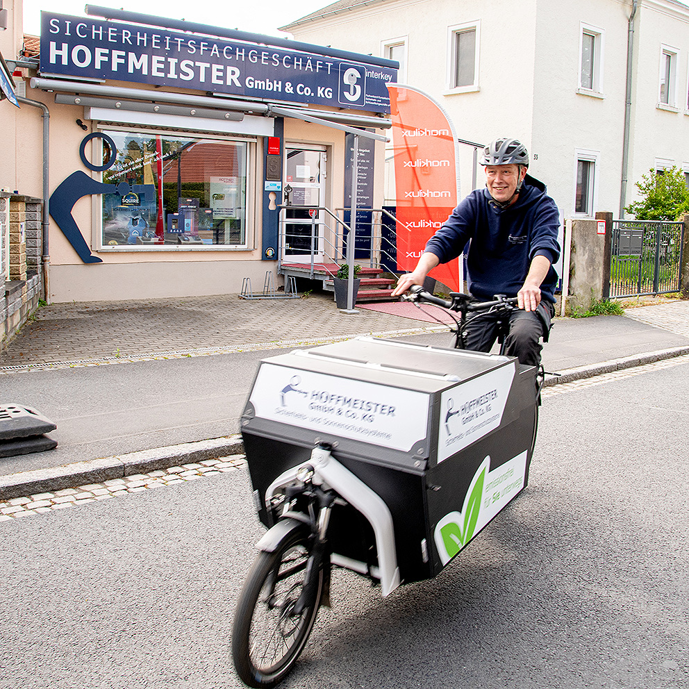 Sven Engler auf Lastenfahrrad vor dem Ladengeschäft